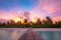 Wooden pier with lights into paradise island in Maldives. Sunset beach landscape, exotic travel vacation destination, summer shore Royalty Free Stock Photo