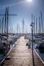 Wooden pier with many boats and yachts in marina harbor