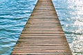 Wooden pier over water with waves on a sunny summer day