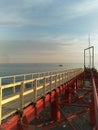 Wooden pier on a red metal support on the sea coast