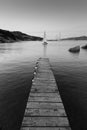 Wooden pier and sailboats sailing in evening calm sea of marvellous Porto Rafael, Costa Smeralda, Sardinia, Italy Royalty Free Stock Photo