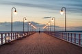 Wooden pier by the sea lit by stylish lamps at night Royalty Free Stock Photo