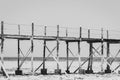 Wooden pier on sunny day, monochrome. Low tide of Indian Ocean. Idyllic exotic resort. Pier in perspective, black and white. Royalty Free Stock Photo