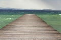 Wooden pier with waves on Lago di Garda Sirmione, Italy Royalty Free Stock Photo