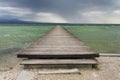 Wooden pier with waves on Lago di Garda Sirmione, Italy Royalty Free Stock Photo