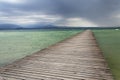 Wooden pier with waves on Lago di Garda Sirmione, Italy Royalty Free Stock Photo