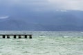 Wooden pier with waves on Lago di Garda Sirmione, Italy Royalty Free Stock Photo