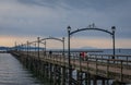 Wooden pier at White Rock, BC, Canada extends diagonally into image. City of White Rock Pier at overcast cloudy day