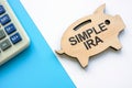 Wooden piggy bank with words SIMPLE IRA plans savings incentive match plans for employees.