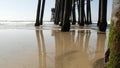 Wooden piles under pier in California USA. Pilings, pylons or pillars below bridge. Ocean waves tide Royalty Free Stock Photo