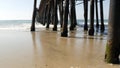 Wooden piles under pier in California USA. Pilings, pylons or pillars below bridge. Ocean waves tide Royalty Free Stock Photo
