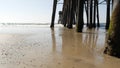 Wooden piles under pier in California USA. Pilings, pylons or pillars below bridge. Ocean waves tide Royalty Free Stock Photo