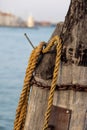 Wooden pillars with old rope and chain in sea at Venice dock. Royalty Free Stock Photo