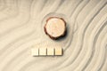 Wooden pine tree stump on the sand top view, four empty cubes on the sand