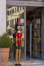 A wooden Pinocchio figure in front of the entrance to a toy store in Rome