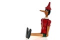 Wooden Pinocchio puppet sitting on white background