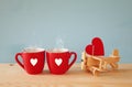 Wooden plane with heart next to couple of coffe cups