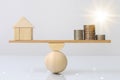 Wooden plank balancing of wood home and coins money comparison of income control expense with light effect graphic. Property inves Royalty Free Stock Photo