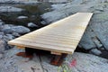 Wooden plank bridge over a small stream in stones Royalty Free Stock Photo