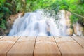 Wooden plank long table top with outdoor theme on blurred waterfall background
