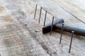 Wooden plank with 6 nails and hammer betwin in focus