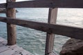 Wooden plank pier fence detail with sea behind