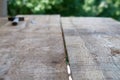 Wooden plank with a pile of nails and hammer in blurred background Royalty Free Stock Photo