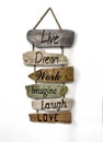 Wooden plank signs hung with rope, with positive messages of live, dream, work, laugh and love, on a white background