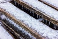 Wooden planks with icicles covered with icy snow