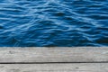 Wooden planks, jetty on the shore, blue water, waves Royalty Free Stock Photo