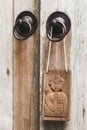 Wooden plate in balinese stile hanging on metal door knob. Don`t disturb sign