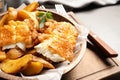 Wooden plate with British traditional fish and potato chips Royalty Free Stock Photo