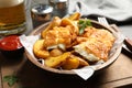 Wooden plate with British traditional fish and potato chips Royalty Free Stock Photo