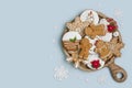 Wooden plate with Christmas homemade gingerbread cookies on blue background Royalty Free Stock Photo