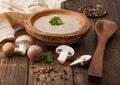 Wooden plate of creamy chestnut champignon mushroom soup with wooden spoon, pepper and kitchen cloth on wooden background Royalty Free Stock Photo