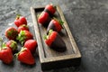 Wooden plate with delicious strawberries and chocolate on grey textured background Royalty Free Stock Photo