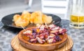 Wooden plate of galician style cooked octopus with potatoes, paprika and olive oil. Pulpo a la gallega.