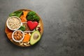 Wooden plate with heart-healthy products on grey background, top view. Space Royalty Free Stock Photo