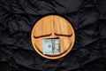 Wooden plate with one hundred dollar bills on a black background, business and finance