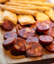 Wooden plate with sliced Spanish tapas, choriso sausage, lomo iberico en bread sticks Royalty Free Stock Photo