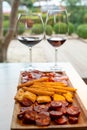 Wooden plate with sliced Spanish tapas, choriso sausage, lomo iberico en bread sticks served with glass of red wine Royalty Free Stock Photo