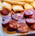 Wooden plate with sliced Spanish tapas, choriso sausage, lomo iberico en bread sticks Royalty Free Stock Photo