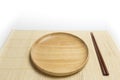 Wooden plate or tray with chopsticks place on a bamboo mat isolated white background Royalty Free Stock Photo