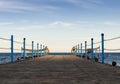 Wooden platform with blue posts with ropes and orange lifebuoys on the background of the sea and sky with clouds Egypt Dahab South