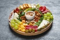 Wooden platter with different tasty appetizers on grey table Royalty Free Stock Photo