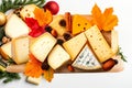 A wooden platter featuring various cheeses, crackers, and wine drinks, set against a festive background Royalty Free Stock Photo