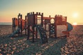 Wooden playground for small children on the beach in sunny morning. Sea sunrise. Royalty Free Stock Photo