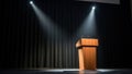 Wooden podium under spotlight on stage with black curtains in empty auditorium Royalty Free Stock Photo