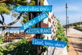 Wooden pointing arrows on the fence. Bar and restaurant on the beach. Ksamil, Albania