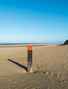 Wooden pole on an empty beach at the North Sea